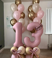Pink number 13 balloons with personalised gold hearts, rose gold balloon bows, a pink, cream and gold base, and matching helium bouquets.