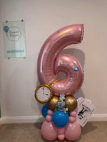 Pink number 6 balloon personalised with Amelia, featuring Alice in Wonderland details, a gold pocket watch, playing cards and a pink, blue and gold base.
