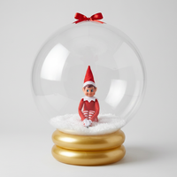Elf on the Shelf inside a clear snow globe with a yellow base.