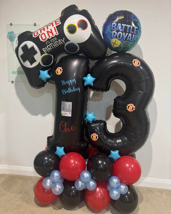 Black number 13 balloons with Manchester United crests, personalised wording and a photo, gaming foil balloons and a red, black and blue balloon base.