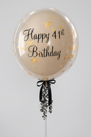 Clear bubble balloon with a neutral inner balloon, gold flake detailing, black Happy 41st Birthday wording and black bow and ribbons.