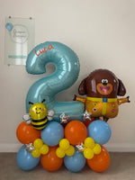 Blue number 2 balloon personalised with Luca, alongside Duggee and bee foil balloons on a blue, orange and yellow base with silver stars