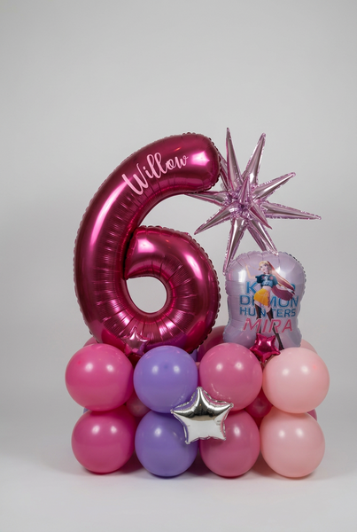 Pink number 6 balloon personalised with Willow, a KPop Demon Hunters Mira balloon, metallic stars and a pink and purple balloon base.
