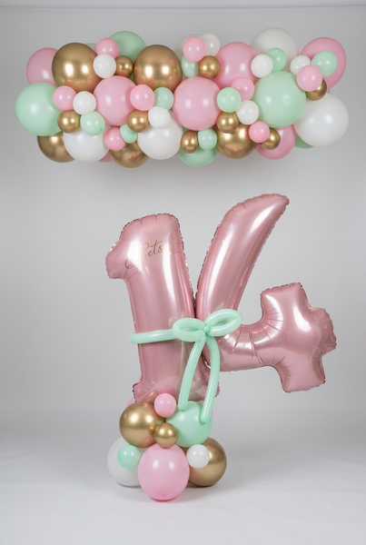 Personalised pink 14 balloons with a mint bow and pastel balloon base, beneath a matching pink, mint, white and gold balloon garland.