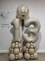 Cream number 13 balloon towers with champagne and cream bases, black bows and a personalised birthday bubble balloon for Brooke.