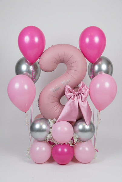 Pink number 8 balloon personalised with Rosie-Mae, with a satin bow, flowers, pink and silver balloon base and two matching helium bouquets.