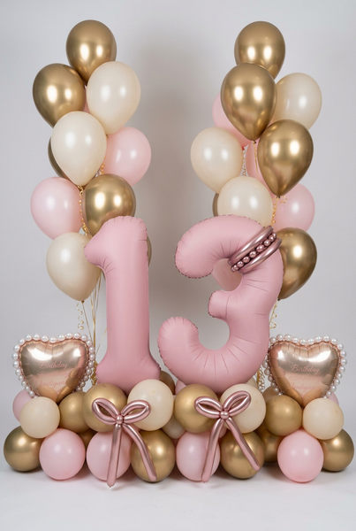Pink number 13 balloons with personalised gold hearts, rose gold balloon bows, a pink, cream and gold base, and matching helium bouquets.