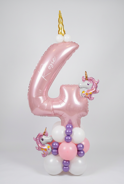Pink number 4 balloon personalised with Rosie, topped with a gold unicorn horn, with two mini unicorn balloons and a pink, white and purple base.