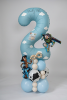 Personalised blue number 2 Toy Story balloon with white clouds, Woody and Buzz Lightyear balloons, and a blue, cream and cow-print base.
