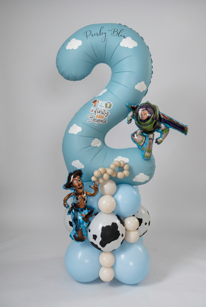 Personalised blue number 2 Toy Story balloon with white clouds, Woody and Buzz Lightyear balloons, and a blue, cream and cow-print base.