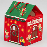 A festive house-shaped gift box or candy box with red and green holiday graphics, illustrated elves, hanging stars, a green roof, red handles, and a front label reading 'This cheeky elf belongs to Alfie & Mia'.