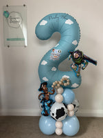 Personalised blue number 2 Toy Story balloon with white clouds, Woody and Buzz Lightyear balloons, and a blue, cream and cow-print base.
