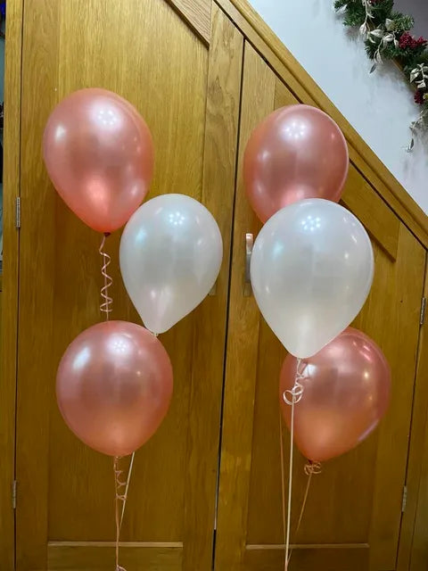 Two rose gold and white helium balloon bouquets, each containing three latex balloons with curling ribbons